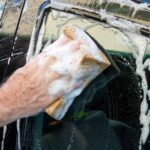 hand-holding-soapy-sponge-washing-car