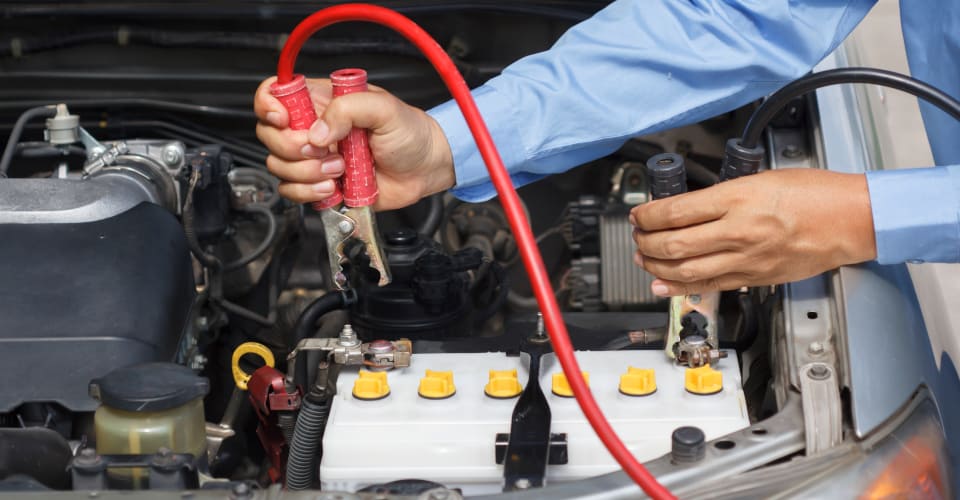 man using jumper cables to start car 1