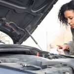 woman-on-phone-opens-car-hood-to-look-at-engine